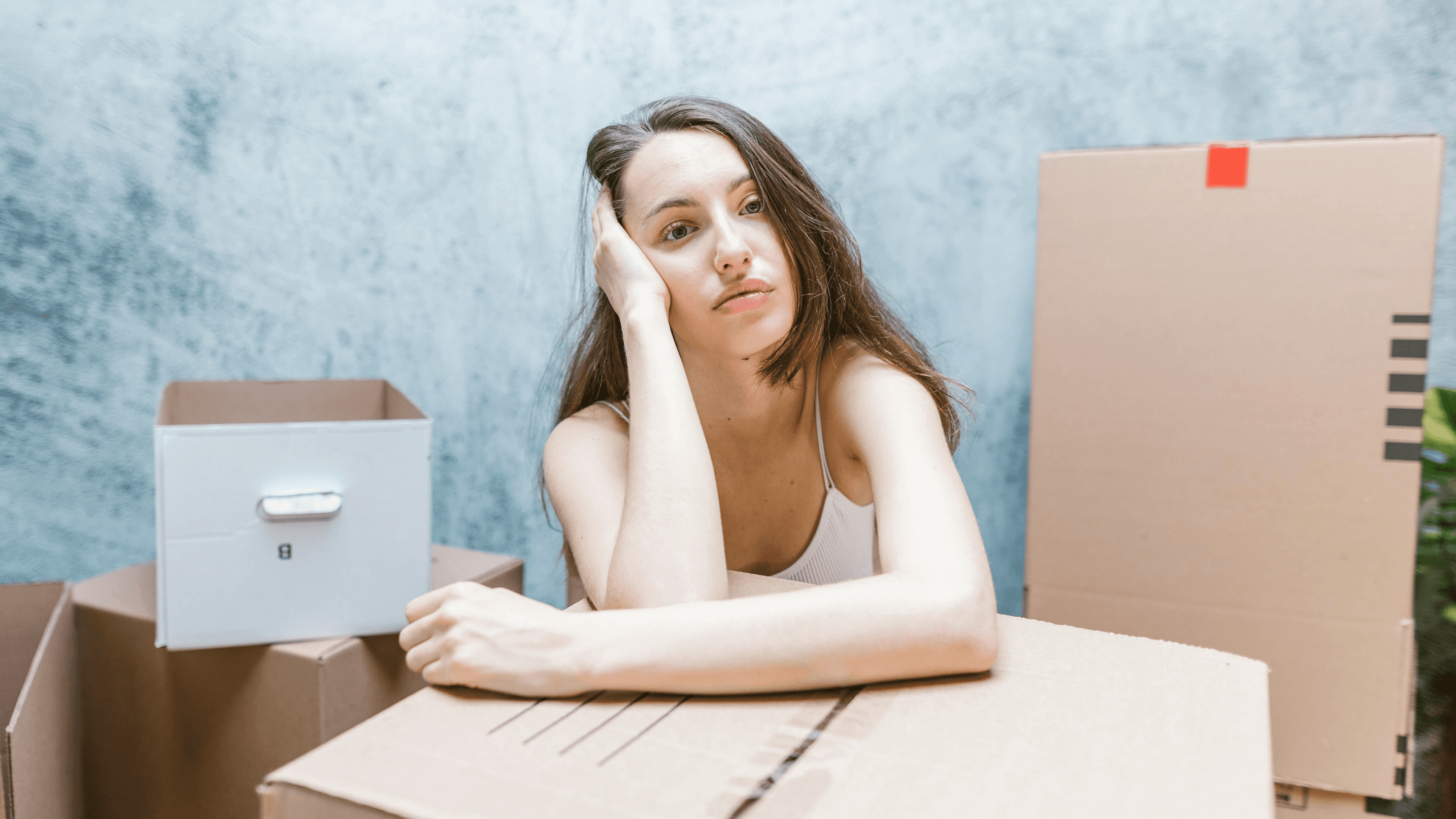 Person sitting with laptop among boxes
